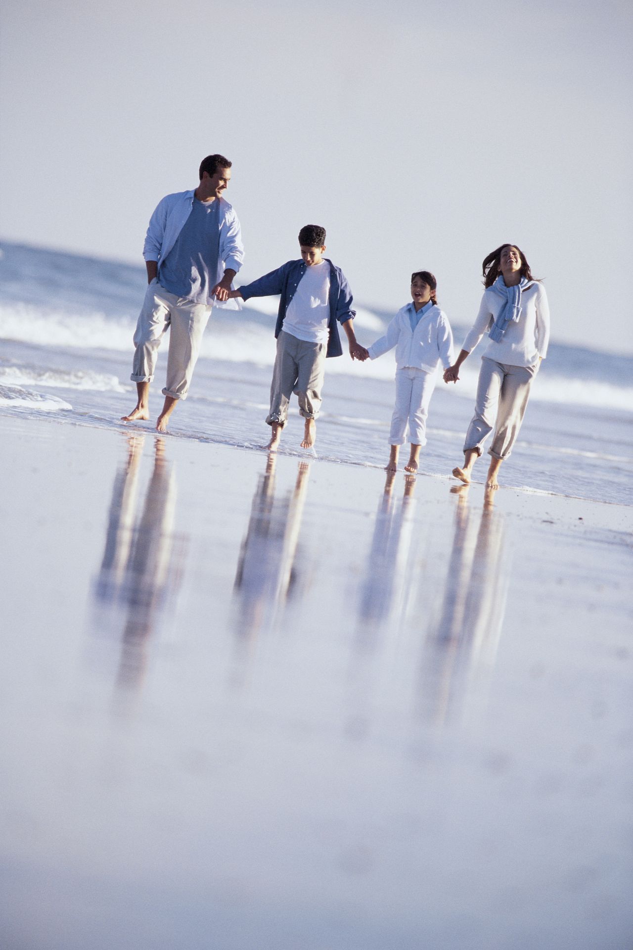 Família rica andando na praia aproveitando as férias em família